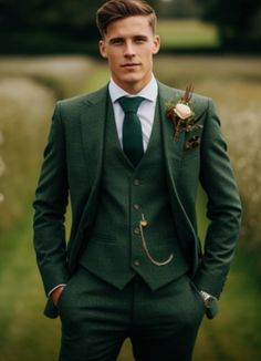 a man wearing a green suit and tie standing in front of a field with flowers