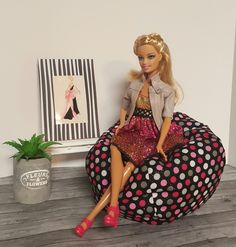 a barbie doll sitting on a bean bag chair