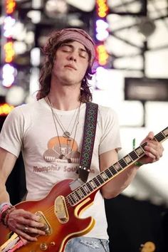 a young man playing an electric guitar on stage