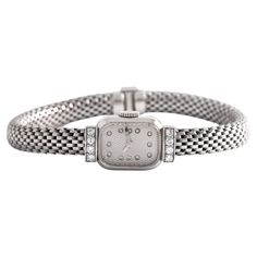 Boucheron Paris Diamond 18K White Gold Wristwatch Set with 8 diamonds. French marks. Circa 1950. Reference number: 72608. Case dimensions: 2.20 x 1.30 centimeters. Length: 18.00 centimeters. Width bracelet: approximately 0.60 centimeters. Weight: 36.12 grams. We do not guarantee the functioning of this watch. Classic Diamond Watch With Jubilee Bracelet For Formal Occasions, Classic Diamond Watch With Polished Finish For Evening, Diamond Watch With Jubilee Bracelet For Anniversary, Luxury Diamond Watch With Jubilee Bracelet For Evening, Diamond Watch With Rectangular Dial For Evening, Classic Evening Diamond Watch With Diamond Hour Markers, Classic Formal Diamond Watch With Jubilee Bracelet, Classic Platinum Diamond Watch For Evening, Classic White Gold Diamond Watch For Evening