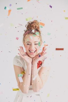 a woman with confetti all over her face and hands in front of the camera