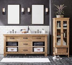 a bathroom with two sinks and three mirrors on the wall next to a cabinet that has towels in it