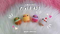 three crochet mini birds sitting next to each other on a fluffy white surface