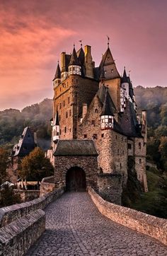 an old castle on top of a hill with a stone walkway leading up to it