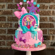 a pink and blue birthday cake with stars on the top is decorated with fondant, sprinkles, and decorations