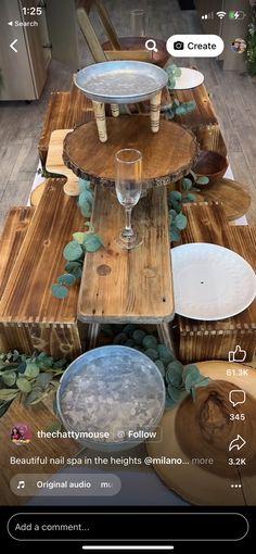 the table is made out of wood and has plates, bowls, and wine glasses on it