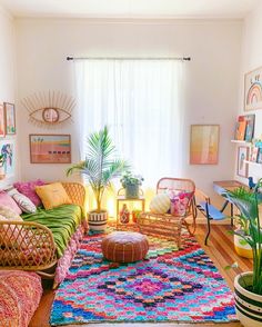 a living room filled with lots of colorful furniture and decor on top of a wooden floor