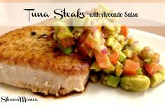 tuna with avocado salsa served on a white plate in front of the caption