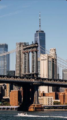 a boat traveling under the brooklyn bridge in new york city