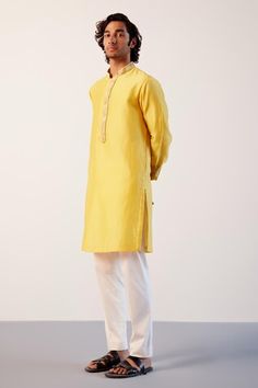 Bright yellow kurta in silk chanderi base with zari embroidery around the neckline and inseam pockets on both sides. Paired with an ivory lycra slim pant. - Aza Fashions Ceremonial Slub Silk Kurta For Diwali, Slub Silk Kurta For Ceremonial Festivals, Ceremonial Slub Silk Kurta For Festivals, Plain Yellow, Yellow Kurta, Zari Embroidery, Men Kurta, Yellow Silk, Band Collar