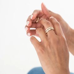 a woman holding onto her wedding ring with one hand and the other on her finger