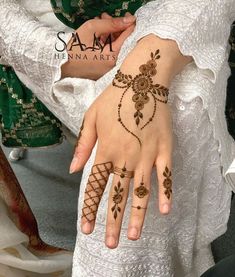 a woman's hand with henna tattoos on it