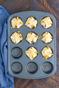 muffin tins filled with cupcake batter sitting on top of a wooden table