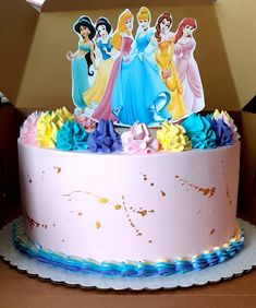 there is a cake decorated with princesses on the top and blue ribbon around the edges