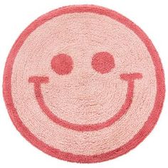 a red and white rug with a smiling face on it's center, in the shape of a circle