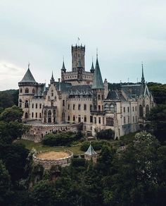 an old castle sitting on top of a lush green hillside