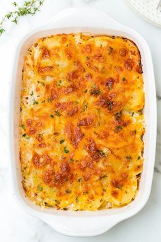 a casserole dish with cheese and meat in it on a marble table top