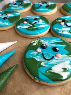 cookies decorated with blue and green icing are sitting on a cookie sheet, ready to be eaten