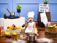 a doll is sitting on the floor in front of some food and cooking utensils