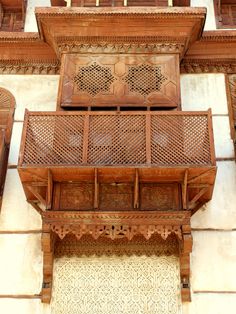 an ornate wooden balcony on the side of a building