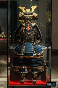 an elaborately decorated samurai armor on display in a glass case