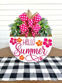 a sign that says hello summer on it with flowers in the center and a bow