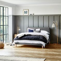 a bed room with a neatly made bed and wooden floors