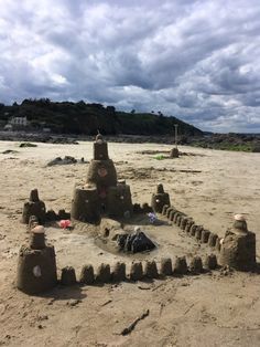 a sand castle on the beach with toys in it