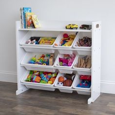 a white book shelf with bins filled with toys and books on top of it