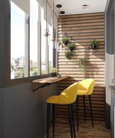 two yellow chairs sitting in front of a counter with potted plants on the wall