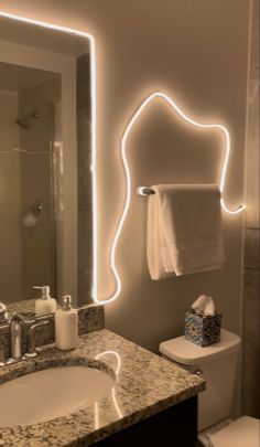 a bathroom with a sink, mirror and toilet in it's center area is lit up by neon lights