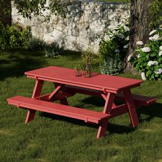 a red picnic table sitting in the grass