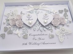 a wedding card with two hearts and flowers in the shape of roses, butterflies and pearls