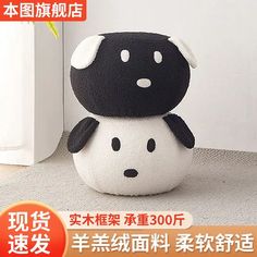 a black and white stuffed animal sitting on top of a floor