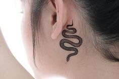 a woman with a tattoo on her neck and behind the ear is a black snake