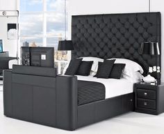 a black and white bedroom with a bed, night stand, nightstands and windows