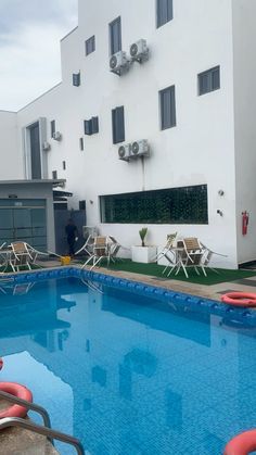 an empty swimming pool in front of a white building