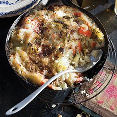 a pan filled with food sitting on top of a table next to a glass bowl