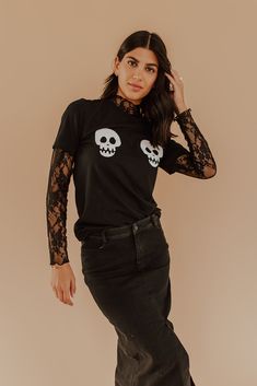 Our SPOOKY SKULLS GRAPHIC TEE IN BLACK will make you stand out this Halloween season! Boasting a stylish skull graphic, this spooky but cute tee is perfect for chilly fall days, when you want to show off your ghoulish sense of style. So don't be scared off by the chill, slip into this super cute tee and slay! Paired with The Floral Lace Mock Neck Top in Black and The Denim Maxi Skirt in Black and The Katie Plaid Skirt in Khaki Crew neck Short sleeve Skeleton graphic Unisex fit 100% combed cotton Lace Shirt Under Graphic Tee, Halloween Style Outfits, Skeleton Shirt Outfit, Lace Layering Top, Halloween Fashion Outfits, Lace Mock Neck Top, Spooky But Cute, Lace Undershirt, Holiday Fits