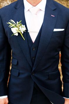 a man in a suit and tie with a boutonniere on his lapel