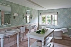 a bathroom with two sinks, a bathtub and a mirror in it's center