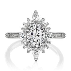 an engagement ring with a large diamond center surrounded by small round diamonds and pave set shoulders