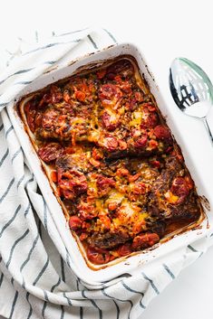 the best oven baked round steak in a casserole dish on a striped towel