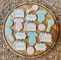 baby shower cookies are arranged on a wooden platter