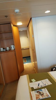 a hotel room with a bed, desk and shelves on the wall next to it