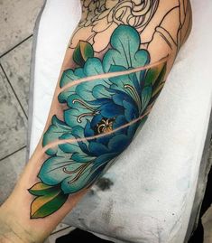 a blue flower tattoo on the arm