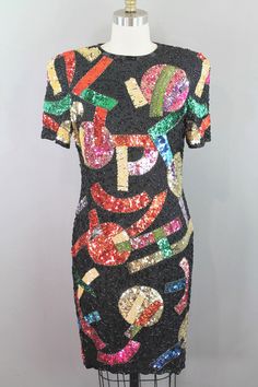 This 1980s-90s beaded cocktail dress is such a fun piece! An Oscar Creations original, this little dress has a unique abstract pattern with letters of the alphabet incorporated throughout. This style has made its way back around...Kelly Clarkson would agree!  Measurements:  *Marked Size 8 Bust- 36in Waist- 32in Hip- 36in Sleeve- 10in Shoulder to Hem- 37in Purveyor's Note: We have searched far and wide, wrestled bears, braved the cold, traversed mountain ranges, fought pirates, swam with sharks and eaten at many a questionable road side taco stand to provide our customers with one of a kind vintage pieces.  Know that whichever piece you choose to make your own has its own story and has traveled through time to get to you.  Though we strive to provide the absolute best, "pristine" vintage pi Mountain Ranges, Beaded Cocktail Dress, L Alphabet, Kelly Clarkson, The Alphabet, Little Dresses, Sharks, Dress Clothes For Women, Abstract Pattern