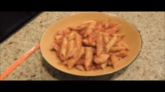 a bowl filled with pasta sitting on top of a counter