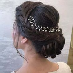 a woman wearing a wedding hair comb with pearls and leaves on it's head