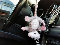 a stuffed animal hanging from the center console of a car